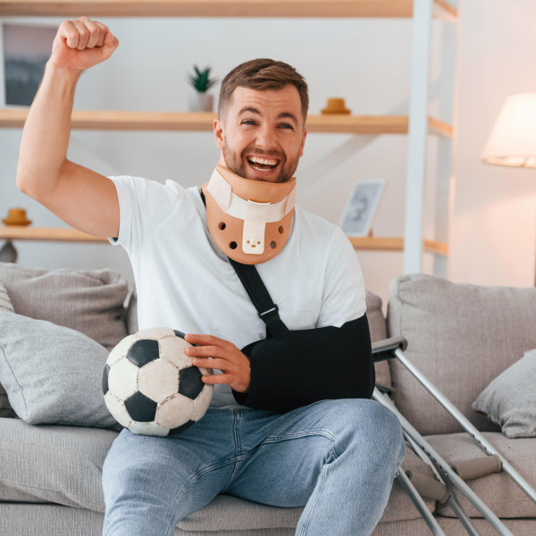 Ein Mann mit Gips schaut ein Fußballspiel